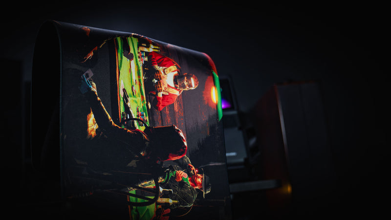 Sleight of Hand Rust gaming deskmat draped over a chair to showcase its flexible premium cloth surface, stitched edges, and detailed poker night artwork.