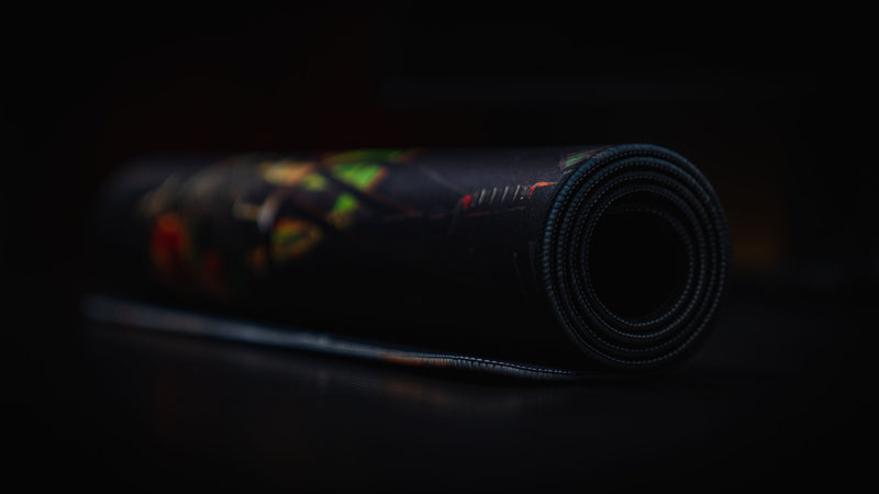 Rolled Sleight of Hand Rust gaming deskmat showcasing its flexible premium cloth surface, stitched edges, and durable anti-slip rubber base.