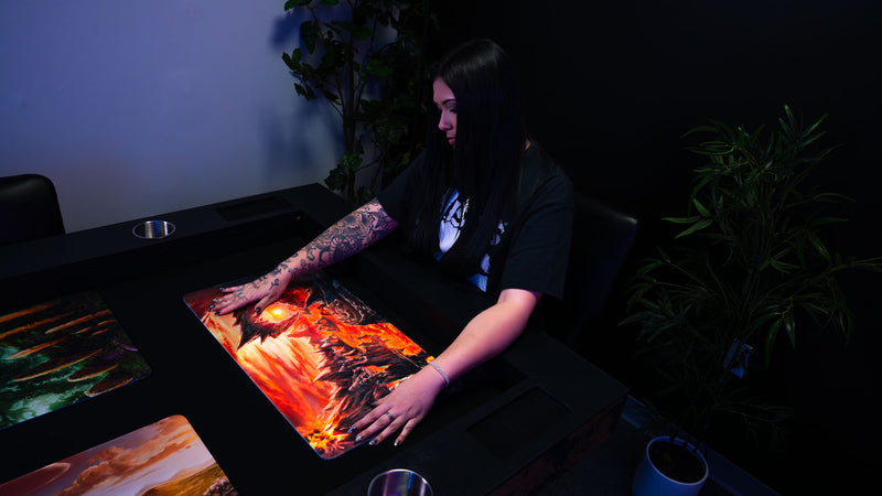 Person displaying the Smoldering Mountain playmat, showcasing its fiery volcanic artwork and full-size dimensions.