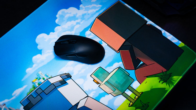 Gaming mouse resting on the Something Like That creator collaboration deskmat featuring colorful block-style characters, bright skies, and adventure-themed artwork.