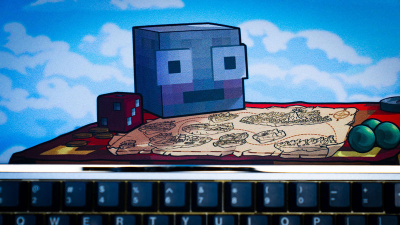 Close-up of the map table, treasure map, and block-style character artwork featured on the Something Like That creator collaboration deskmat with mechanical keyboard.