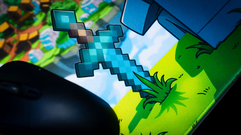 Close-up of a pixel-style diamond sword artwork on the Something Like That creator collaboration deskmat with gaming mouse and vibrant fantasy scenery.