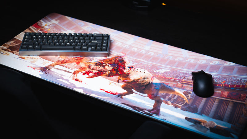 The Spinosaurus Chompers deskmat by Keenling shown with a keyboard and gaming mouse, featuring a fierce Spinosaurus and Triceratops battle inside a Roman gladiator arena.