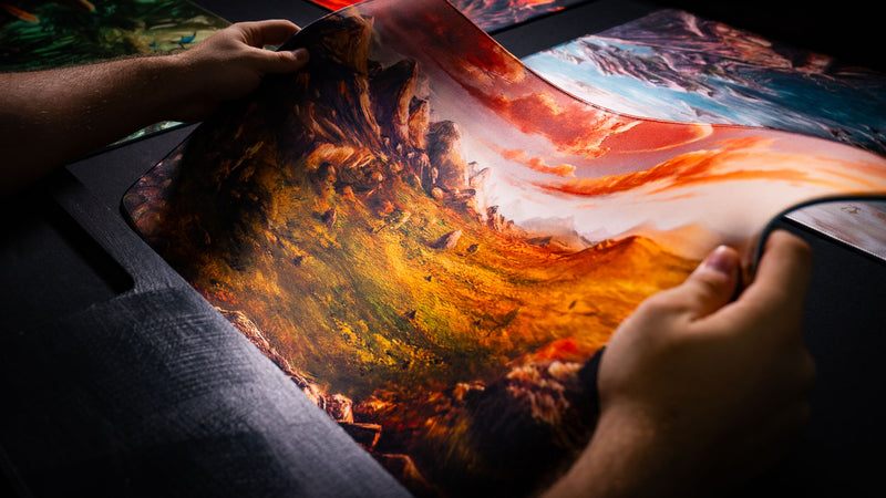 Close-up of the Sunspire Plains fantasy playmat being flexed, highlighting detailed grassland artwork, stitched edges, and premium construction.