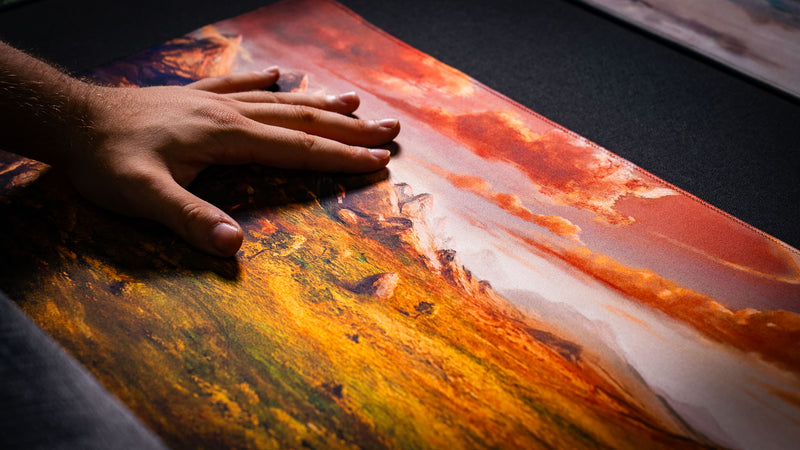 Close-up detail of the Sunspire Plains fantasy playmat showing vibrant grasslands, rocky terrain, and premium high-definition print quality.