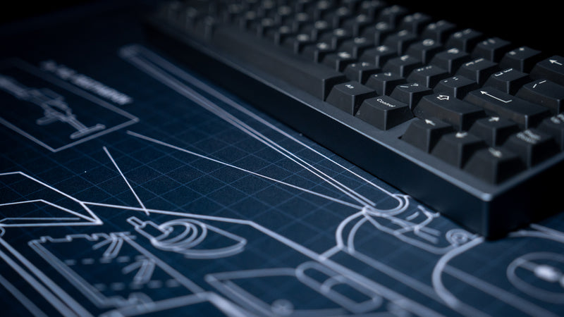 Close-up of the Jimarkus T-34 Schematic deskmat featuring the T-34-85 cannon blueprint beneath a mechanical keyboard with detailed technical line art.