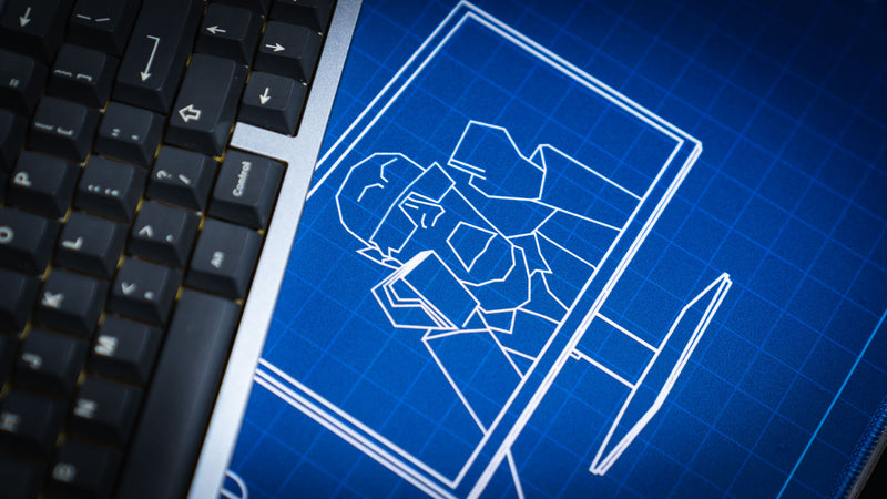 lose-up of the Thermal Receipt Printer blueprint deskmat inspired by Rust, featuring the blueprint-style Bringius monitor illustration beside a mechanical keyboard on a premium blue extended gaming mouse pad.