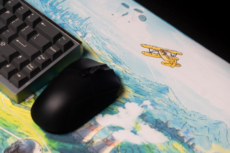Close-up of the yellow biplane and distant city artwork on Torak's Dead Horizon desk mat beside a mouse.