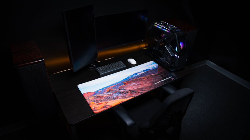 Trail to Delicate Arch deskmat displayed in a modern gaming workstation, featuring panoramic Arches National Park photography, premium stitched edges, and vivid HD print.