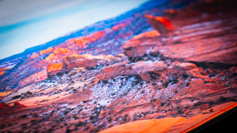 Close-up detail of the Trail to Delicate Arch deskmat showcasing the rugged red rock landscape, HD print quality, and premium stitched edge finish.