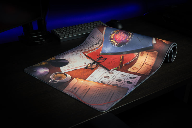 Partly rolled Detective Perspective desk mat showing case-file artwork and its stitched edge
