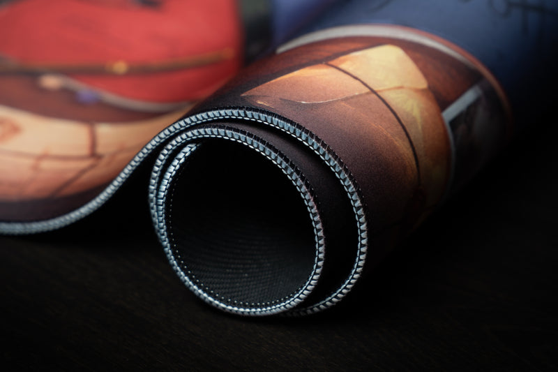 Close-up of the rolled Ty Notts desk mat showing the stitched edge and black rubber underside