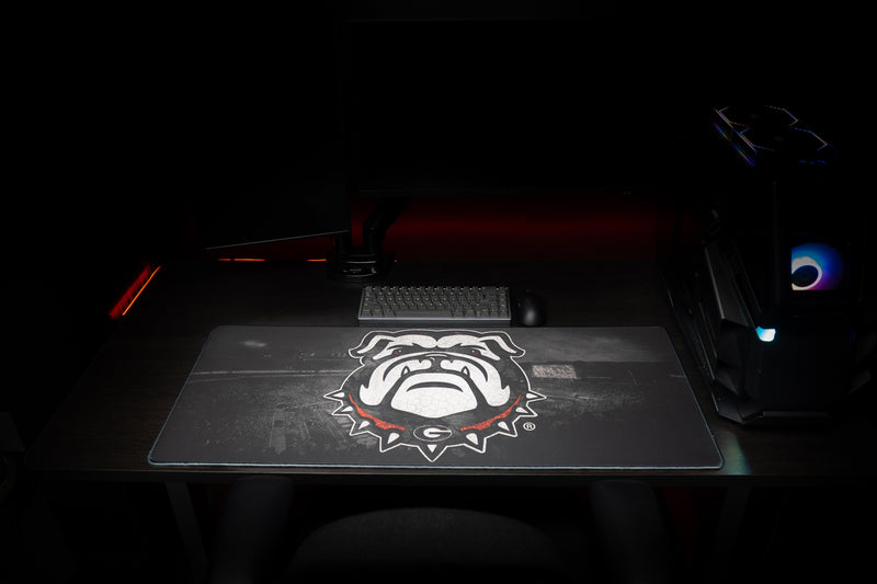 Front view of the Georgia Bulldogs Home Turf deskmat with bulldog mascot beneath a keyboard.