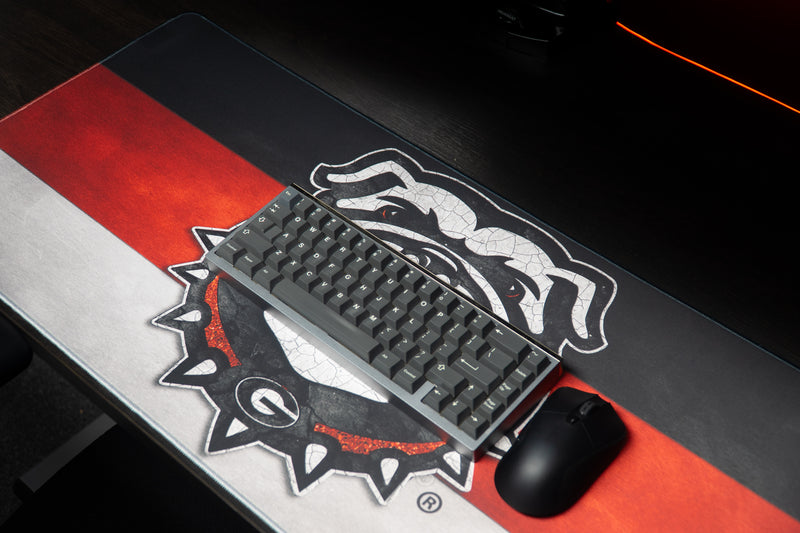 Keyboard and mouse on the Georgia Bulldog's Pride deskmat over its red, black, and white stripes.