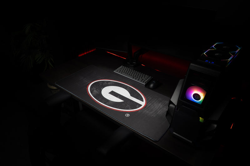Angled workstation view of the University of Georgia Grit deskmat with white G logo.