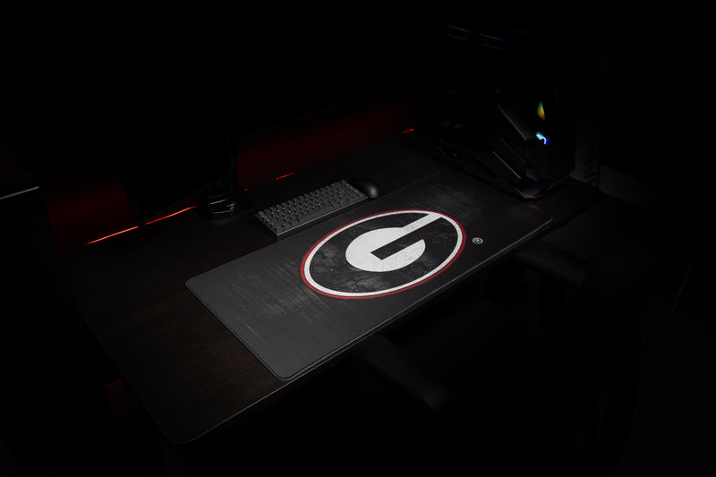 Wide desk setup featuring the University of Georgia Grit deskmat and G logo.