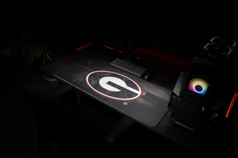 Angled gaming setup with the University of Georgia Home Turf deskmat and centered G logo.