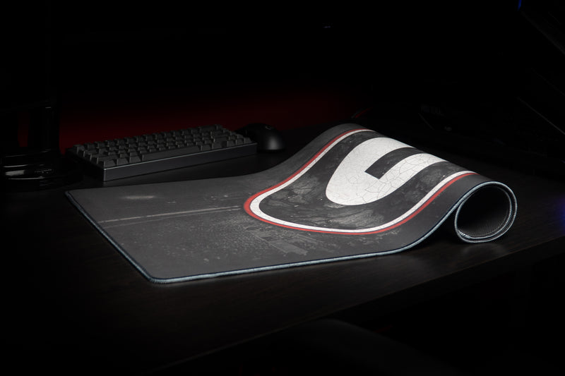 University of Georgia Home Turf deskmat partially rolled beside a keyboard and mouse.