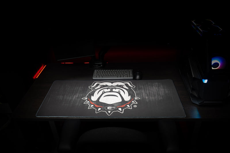 Front view of the Georgia Mark of the Bulldog deskmat beneath a keyboard.