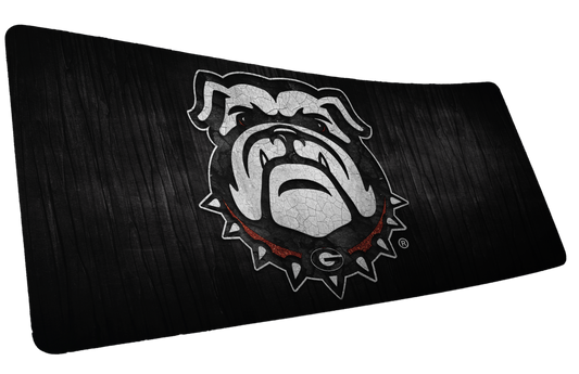 University of Georgia Mark of the Bulldog deskmat with white bulldog mascot on a black wood-grain background.