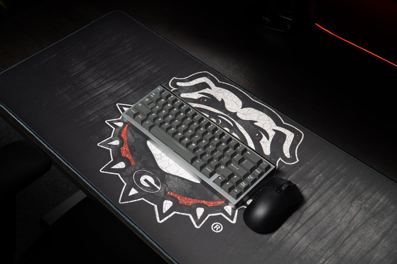 Keyboard and mouse on the Georgia Mark of the Bulldog deskmat.