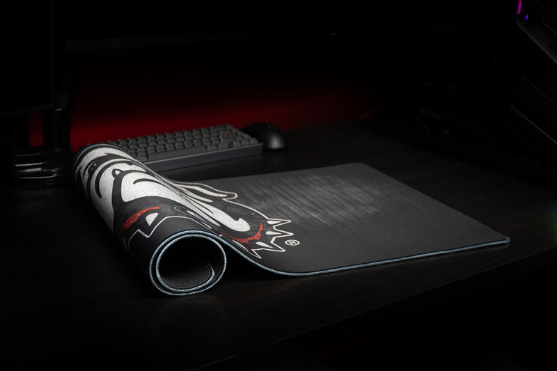 Georgia Mark of the Bulldog deskmat partly rolled on a desktop.