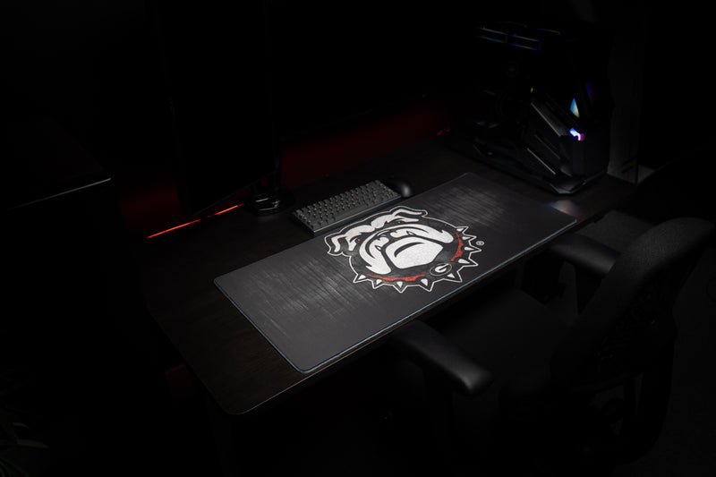 Wide view of the Georgia Mark of the Bulldog deskmat in a dark gaming setup.