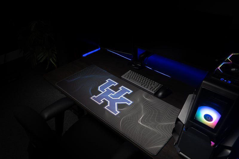 Kentucky Afterglow deskmat across a workstation with its UK logo and flowing line pattern visible.