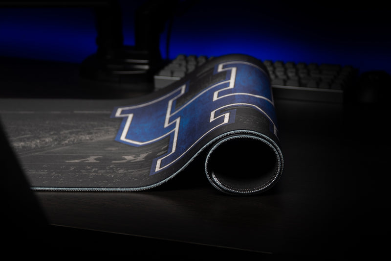 Rolled edge of the Kentucky Home Turf deskmat showing the blue UK logo and stitched border.