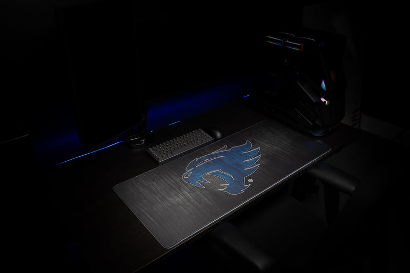 Angled view of the Kentucky Mark of the Wildcat deskmat on a dark desktop.