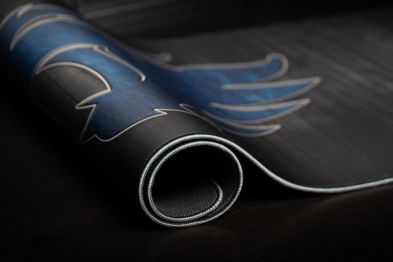 Rolled Kentucky Mark of the Wildcat deskmat showing the blue logo and stitched edge.
