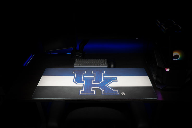 Front view of the Kentucky Pride deskmat in a gaming setup, showing the blue UK logo and striped design.