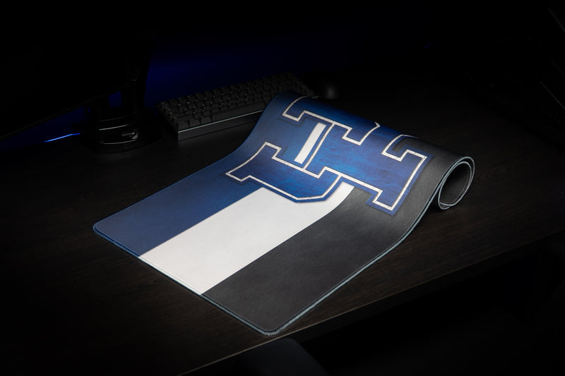 Kentucky Pride deskmat partly rolled, showing its blue UK logo and bold horizontal stripes.