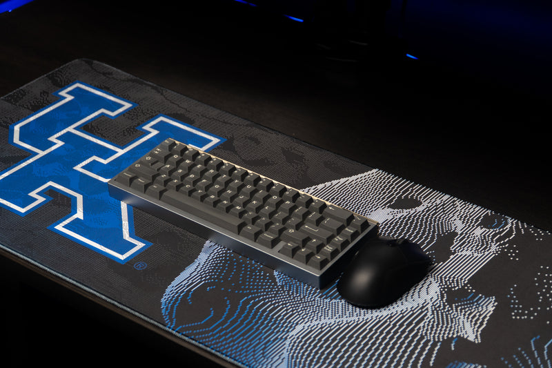 Keyboard and mouse resting on the Kentucky Sound Wave deskmat with blue UK logo and wildcat artwork.
