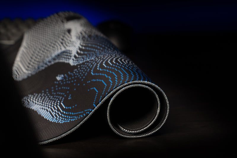 Rolled edge of the Kentucky Sound Wave deskmat showing its blue and white wildcat pattern and stitched border.