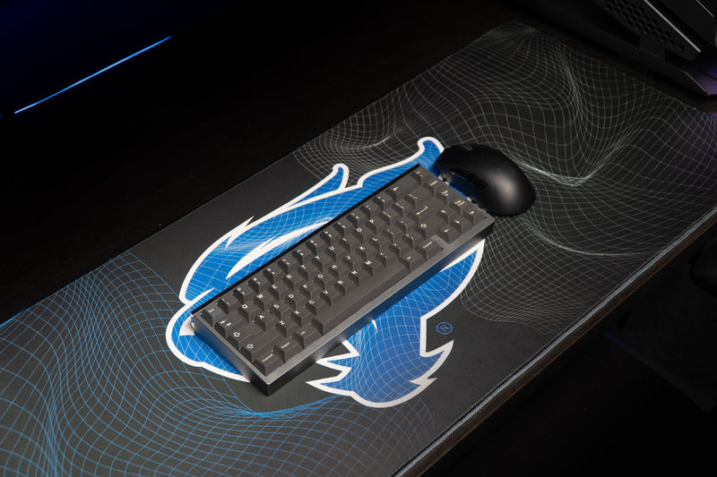 Keyboard and mouse resting on the Kentucky Wildcat Afterglow deskmat and blue wildcat design.