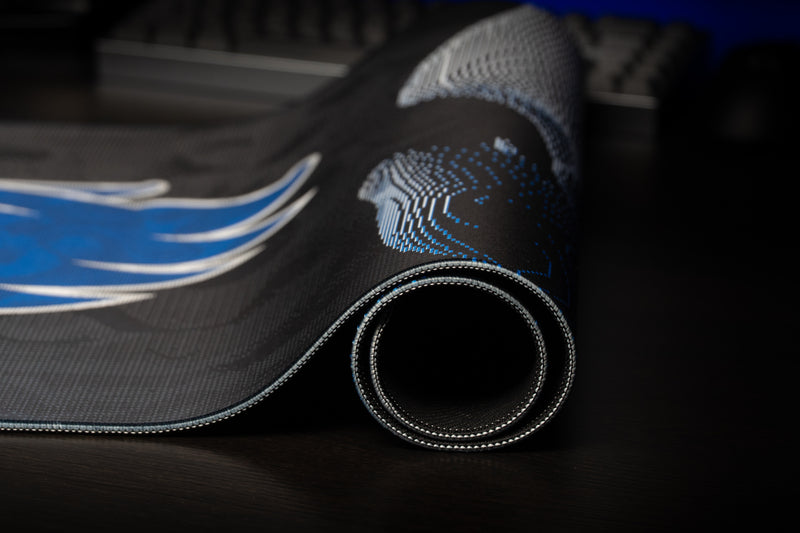 Rolled edge of the Kentucky Wildcat Soundwave deskmat with stitched border and abstract pattern.