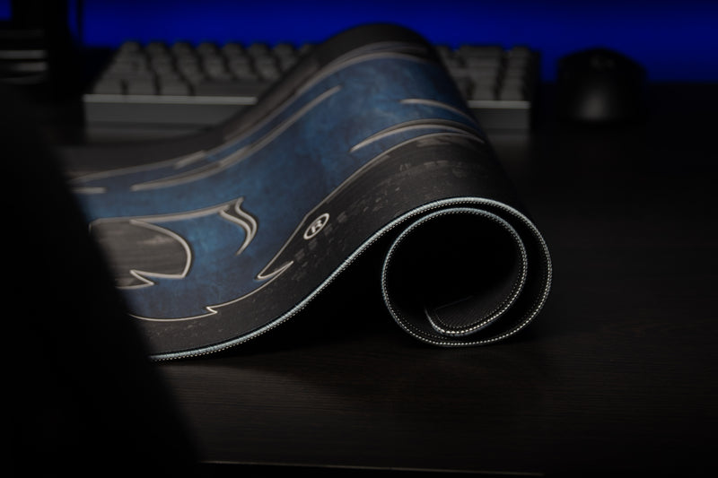 Rolled edge of the Kentucky Wild Cat's Home Turf deskmat with blue wildcat artwork and stitched border.