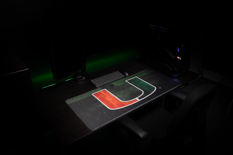 Angled view of the University of Miami Home Turf deskmat showing the orange-and-green U artwork