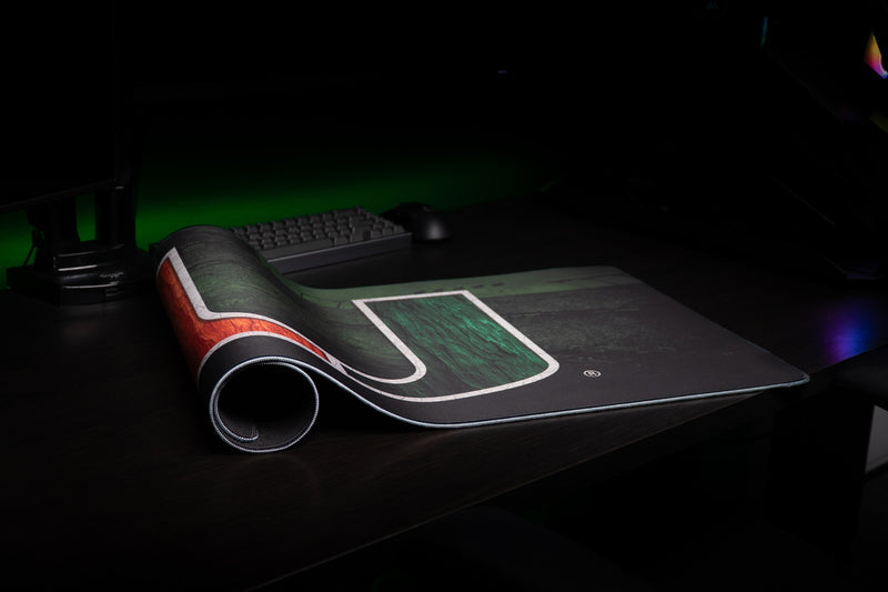 Rolled corner of the University of Miami Home Turf deskmat showing the U artwork and stitched edge