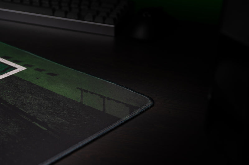 Close-up of the University of Miami Home Turf deskmat stitched edge and dark stadium artwork