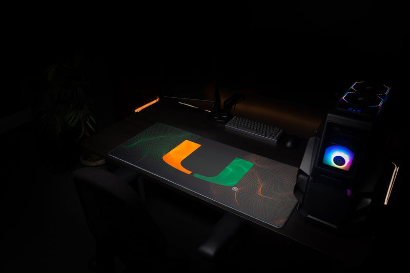 University of Miami Hurricane Flowstate deskmat angled view of the Hurricane Flowstate deskmat beside a gaming PC