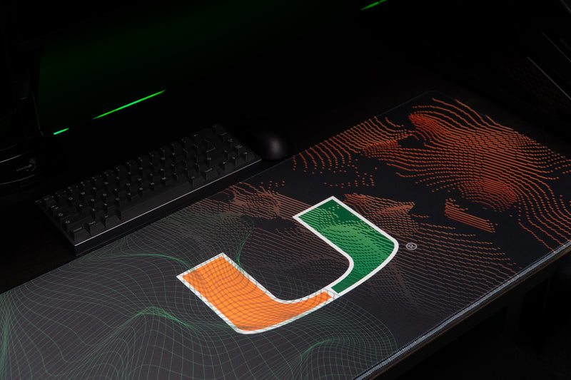 University of Miami Miami Surge deskmat angled detail of the U, green wireframes, and orange currents