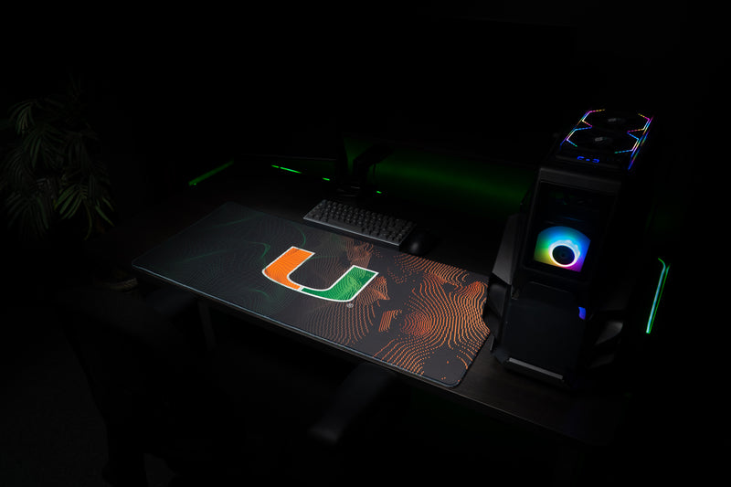 University of Miami Miami Surge deskmat angled view of the full Miami Surge deskmat beside a gaming PC