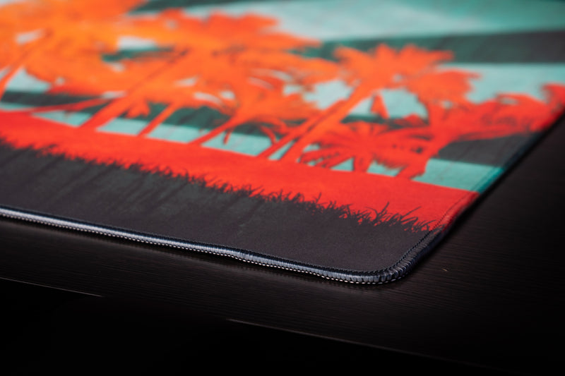 University of Miami Sebastian in Paradise deskmat close-up of orange palm artwork and the stitched corner