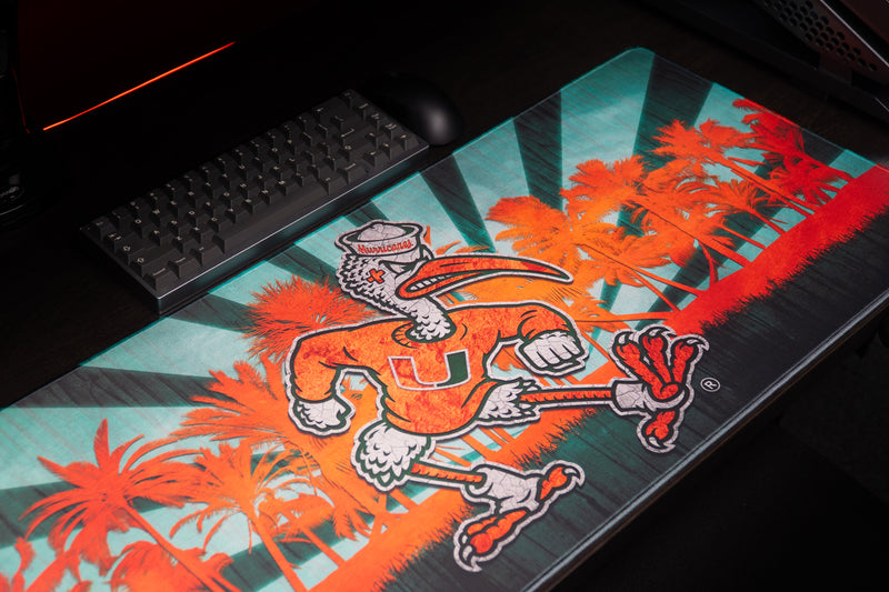 University of Miami Sebastian in Paradise deskmat close angled view of Sebastian and orange palms beside a keyboard