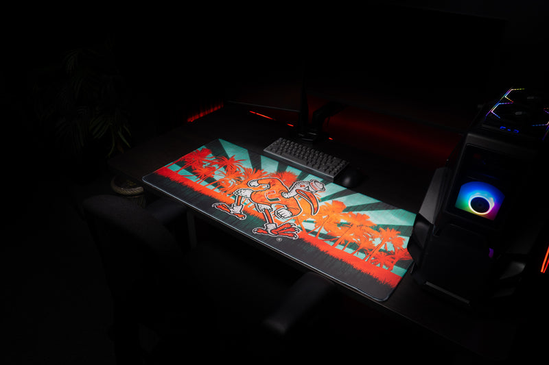 University of Miami Sebastian in Paradise deskmat angled view of Sebastian in Paradise beside a gaming PC
