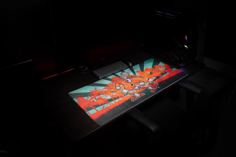 University of Miami Sebastian in Paradise deskmat wide angled view of the tropical Sebastian deskmat in a gaming setup