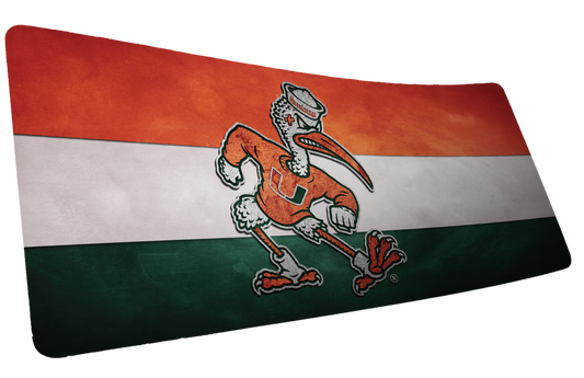 University of Miami Sebastian Pride deskmat mockup of Sebastian over orange, white, and green stripes