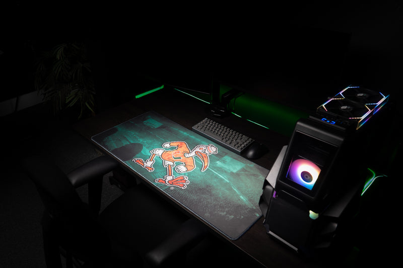 University of Miami Sebastian's Home Turf deskmat angled view of the full deskmat beside a gaming PC